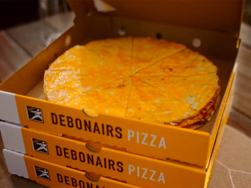 Triple decker pizza in a delivery box